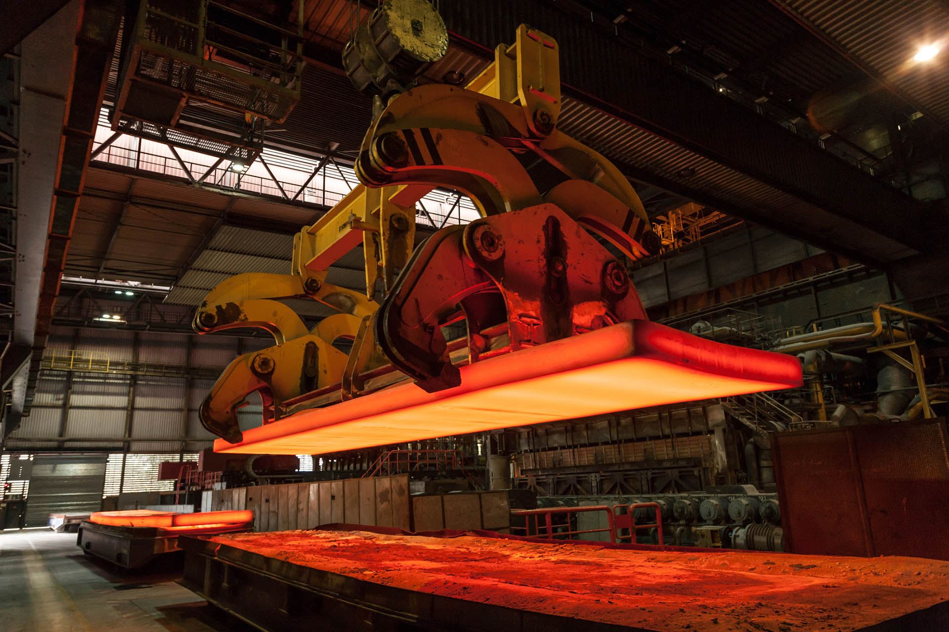 Metal crane moving a hot mass of steel with power